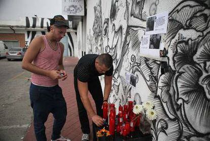 Dos amigos de Cosmin Virgil Costea encienden unas velas en un altar improvisado a las puertas de la discoteca Pícaro, donde cayó abatida la víctima.