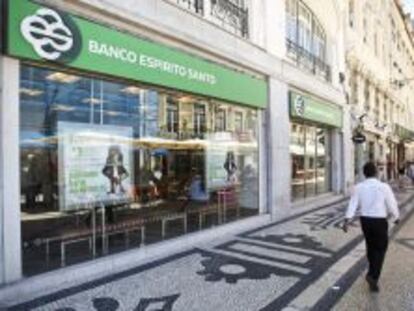 Un hombre camina junto a una sucursal del Banco Espirito Santo en Lisboa. 