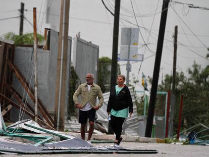 Turistas caminan entre los escombros que cubren la calle después de la llegada del huracán Zeta a Playa del Carmen, México