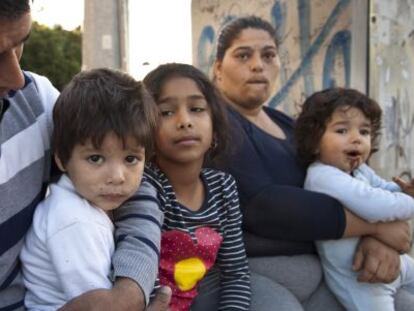 Juana Amador con sus hijos y su marido ante el polideportivo Ciudad Jardín de Alicante en el que se encuentran alojados.