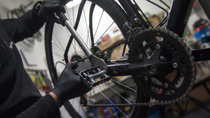 Un hombre arregla una bicicleta en un taller de Madrid.