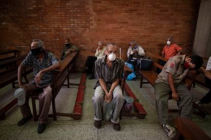 A group of people wait to receive free food at a church in Caracas in May 2020.