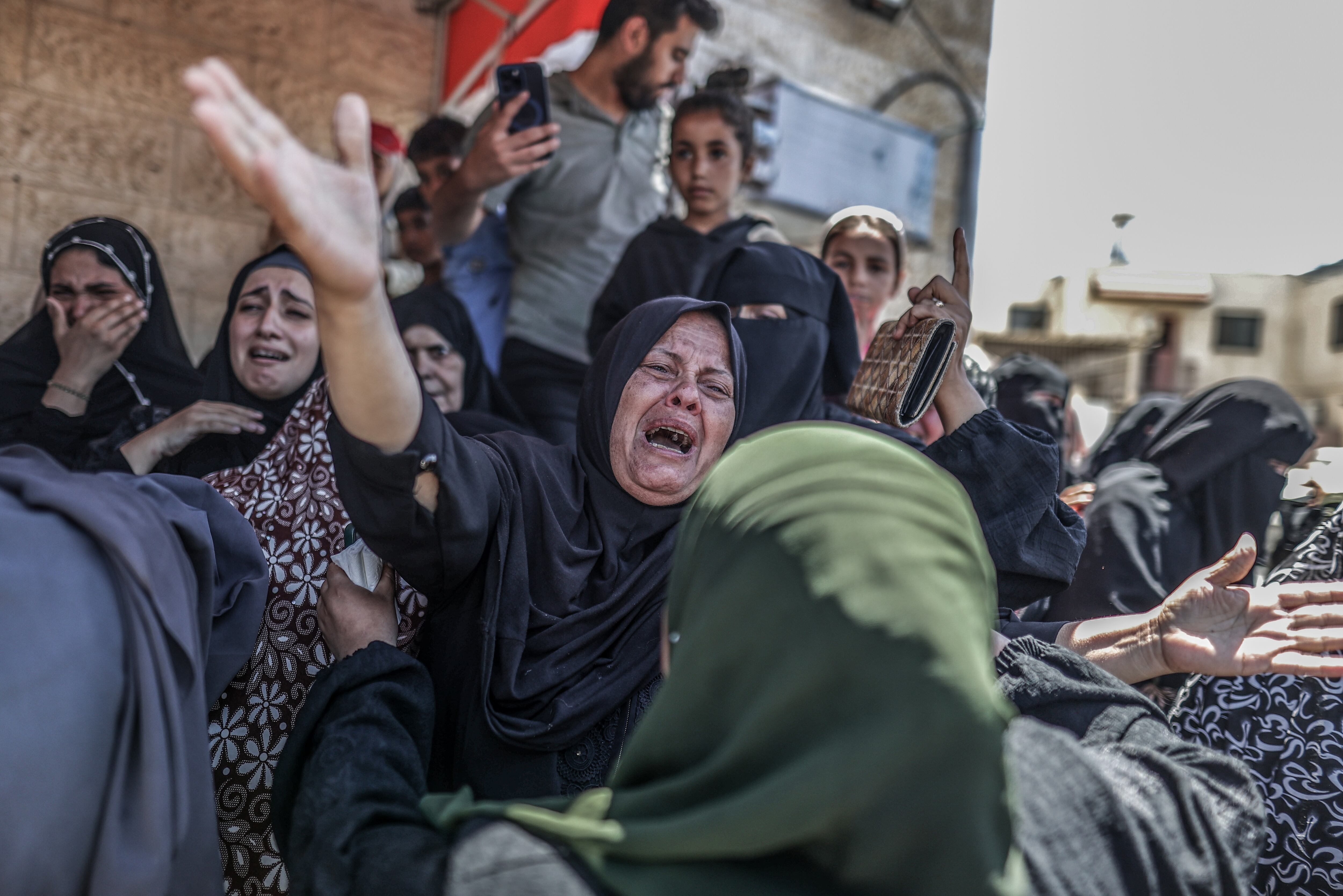 DEIR AL-BALAH, GAZA - JUNE 11: Relatives of those who lost their lives as a result of the Israeli army's attack mourn as their bodies are brought to al-Aqsa Martyrs Hospital for burial in Deir al-Balah, Gaza on June 11, 2024. (Photo by Ali Jadallah/Anadolu via Getty Images)
