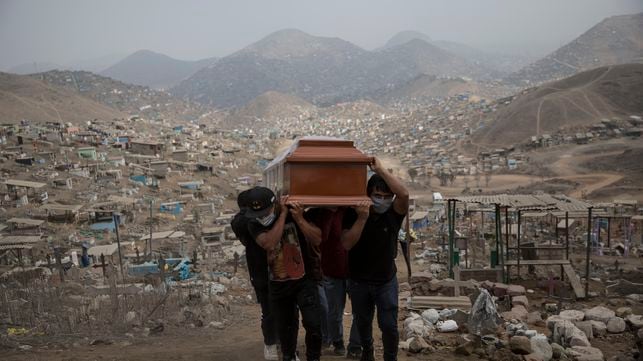 Familiares llevan el ataúd de una presunta víctima de COVID-19 en el cementerio Nueva Esperanza en las afueras de Lima, Perú en 2020.