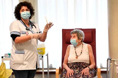 Una enfermera prepara la vacuna para una anciana de una residencia en las afueras de París