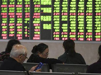 Un grupo de personas observa un panel con la evolución de los mercados bursátiles, en Chengdu, provincia de Sichuan (China).