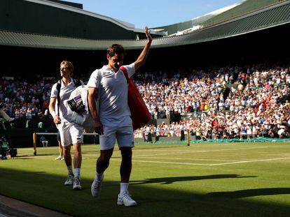 Federer se despide del público de la Pista 1, con Anderson detrás, este miércoles en Wimbledon.