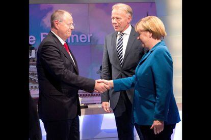 Angela Merkel saluda a su oponente del SPD, Peer Steinbrueck , en presencia del l&iacute;der de los verdes, Juergen Trittin, tras el programa de televisi&oacute;n en el que han participado esta noche para analizar los resultados electorales.