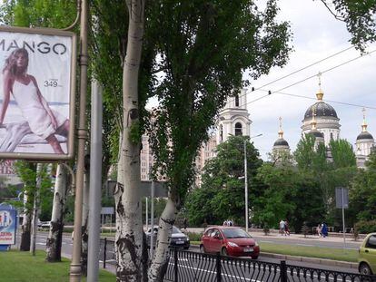 Tráfico en una de las avenidas de Donetsk. En primer término, un cartel publicitario de moda de mujer.