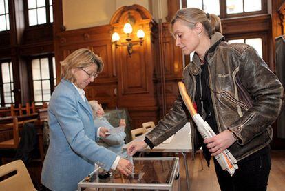 Una mujer deposita su voto en un colegio electoral de París