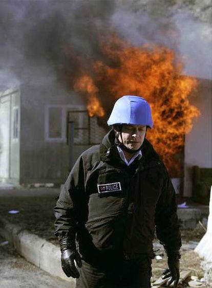 Un policía de la ONU, ante el incendio provocado por manifestantes serbios.