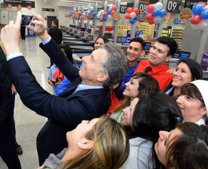 Macri se fotografía con empleados de un nuevo supermercado.