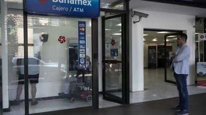 Un cliente hace fila para usar un cajero automático en una sucursal bancaria de Banamex, en Ciudad de México.