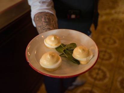 Un camarero sostiene un plato típico de huevos con mayonesa en el Bouillon Republique de París.