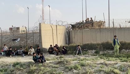 Un grupo de personas espera en los accesos del aeropuerto de Kabul. 