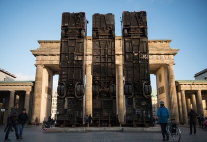 Vista de la obra 'Monument', del artista alemán de origen sirio Manaf Halbouni, delante de la Puerta de Brandenburgo en Berlín (Alemania). La pieza esta compuesta de tres autobuses y recuerda a las barreras formada por estos vehículos en las calles de la ciudad siria de Alepo para proteger a la población civil de los francotiradores. Esta obra forma parte de la iniciativa artística 'Herbstsalon', que se celebra este mes en la capital alemana.