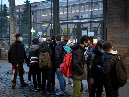 Un grupo de alumnos esperan ante el colegio La Sedeta de Barcelona para retomar el curso tras las vacaciones de Navidad.