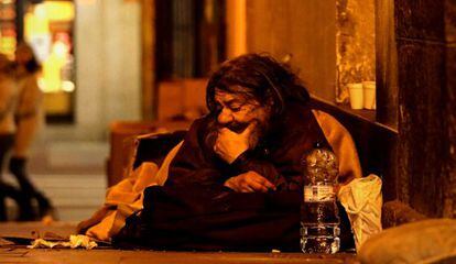 Un hombre duerme en uno de los soportales de la plaza Mayor.