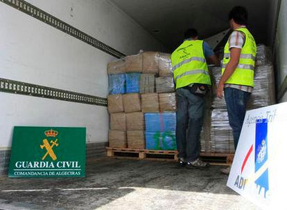 Dos agentes de la Guardia Civil inspeccionan los fardos de droga que se han incautado en un semirremolque en el puerto de Algeciras (Cádiz).