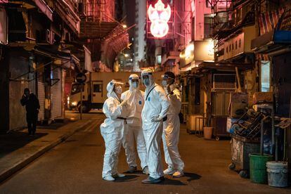 Trabajadores del gobierno con equipos de protección en una calle en la zona confinada del distrito de Jordania en Hong Kong, China. El gobierno de Hong Kong bloqueó a decenas de miles de residentes para contener un brote cada vez más grave del coronavirus.
