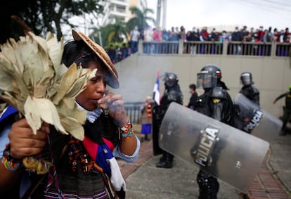 Un indígena lleva a cabo un ritual junto a las autoridades que tratan de dispersar a manifestantes en Cali, el pasado 28 de abril.