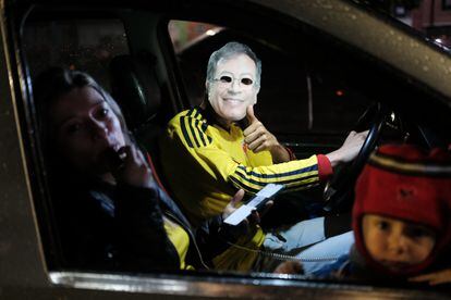 Un hombre con máscara del rostro de Gustavo Petro y su familia celebran su victoria, en Bogotá.