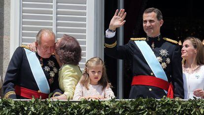 La reina Sofía besa al rey Juan Carlos en el balcón del palacio Real de Madrid, mientras el rey Felipe saluda al público congregado en la plaza de Oriente, junto a la princesa Leonor y la reina Letizia, en la proclamación de Felipe VI, el 19 de junio de 2014.