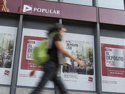 Una mujer pasa ante una oficina del Popular.