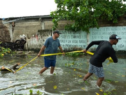 Habitantes tratan de limpiar y arreglar los daños causados por el paso del huracán 'Julia', en San Andrés (Colombia).