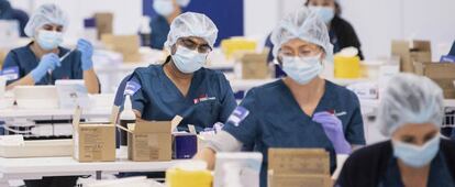 Un grupo de sanitarios prepara vacunas de Pfizer para una jornada de vacunación masiva en Sindey (Australia).