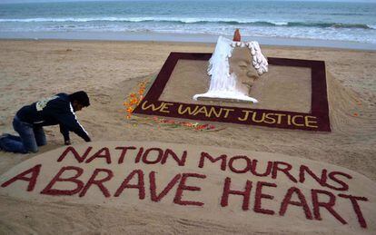 El escultor de arena Sudarshan Pattnaik ultima un monumento en la playa de Puri. "Queremos justicia. La nación llora a un corazón valiente", señala la inscripción.