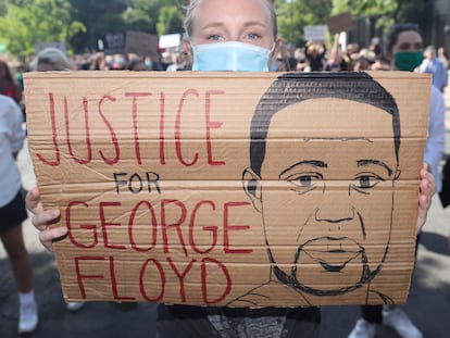 Una manifestante sujeta una pancarta que pide justicia para George Floyd.