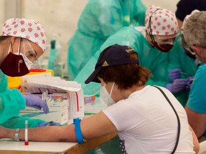 Personal sanitario extrae sangre en un test de covid en Torrejón de Ardoz en Madrid, en mayo.