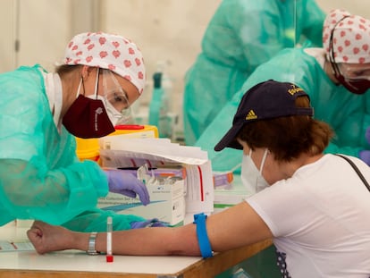 Personal sanitario extrae sangre en un test de covid en Torrejón de Ardoz en Madrid, en mayo.