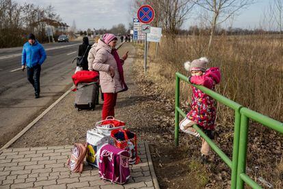 Una familia ucrania espera con sus pertenencias en el cruce fronterizo de Astely-Beregsurany con Hungría.