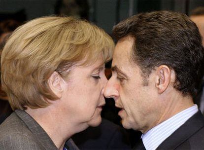 Angela Merkel y Nicolas Sarkozy se saludan esta mañana al comienzo de la segunda jornada de la cumbre de Bruselas.
