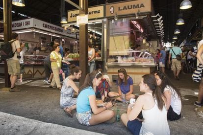 Un grupo de turistas come en el suelo de La Boqueria.