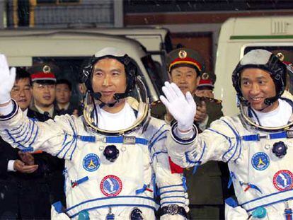 Los astronautas chinos Fei Junlong (izquierda) y Nie Haisheng saludan antes del lanzamiento.