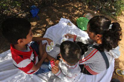 Un grupo de niños sirios juega a las cartas en un pequeño campamento junto al Ceti de Melilla.