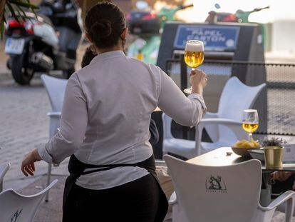 Una empleada de un bar de Sevilla sirve una cerveza, este domingo.