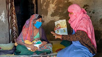 Reena Patidar, activista de una asociación en favor de la lactancia materna, explica los beneficios de la misma a Latha Raju Masaur en Jethana, un pueblo de India.