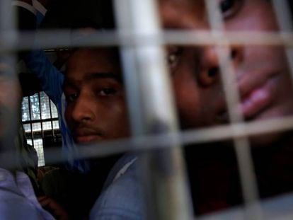 Un grupo de hombres de la minoría rohinyá mira desde el interior de un vehículo de la policía en Myanmar.