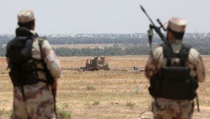 Milicianos armados de Hamás observan un vehículo militar del Ejército israelí en el paso de Rafah, en el sur de la franja de Gaza.