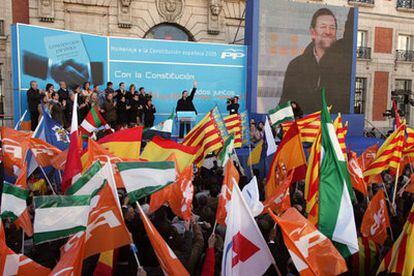 Rajoy saluda desde la tribuna a las personas que han participado en el acto en la Puerta del Sol.