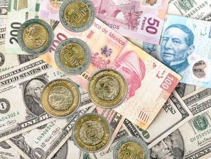 Billetes y monedas de pesos mexicanos sobre dólares.