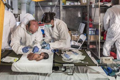 Los enfermeros del Cantabria atienden a un recién nacido en una patera rescatada.
