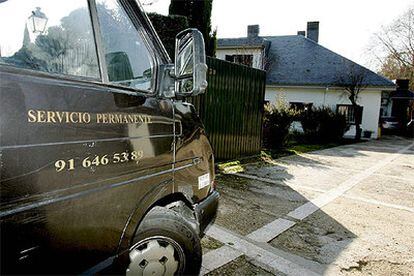 Un vehículo del servicio funerario, en la vivienda de Villanueva de la Cañada donde se ha perpetrado el crimen.