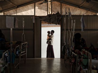 Nyukouth sostiene a su hermana Nyawan en el hospital de MSF en el campo de Bentiu. Tenía neumonía y fiebre alta, pero se está recuperando bien.