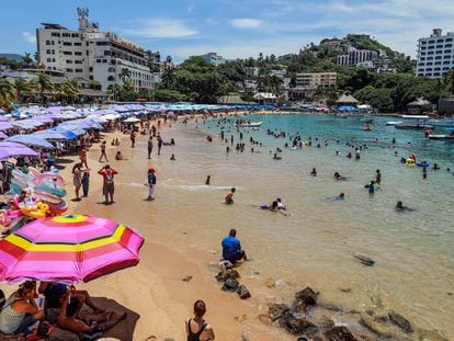 Turistas disfrutan en una playa del pacífico mexicano, el 9 de agosto, en Acapulco, Estado de Guerrero (México).