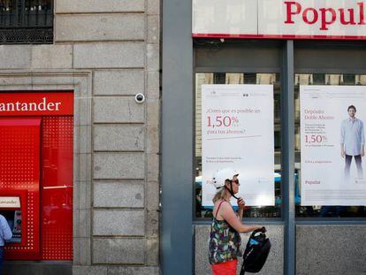 Imagen de un cajero del Banco Santander junto a una sucursal del Popular